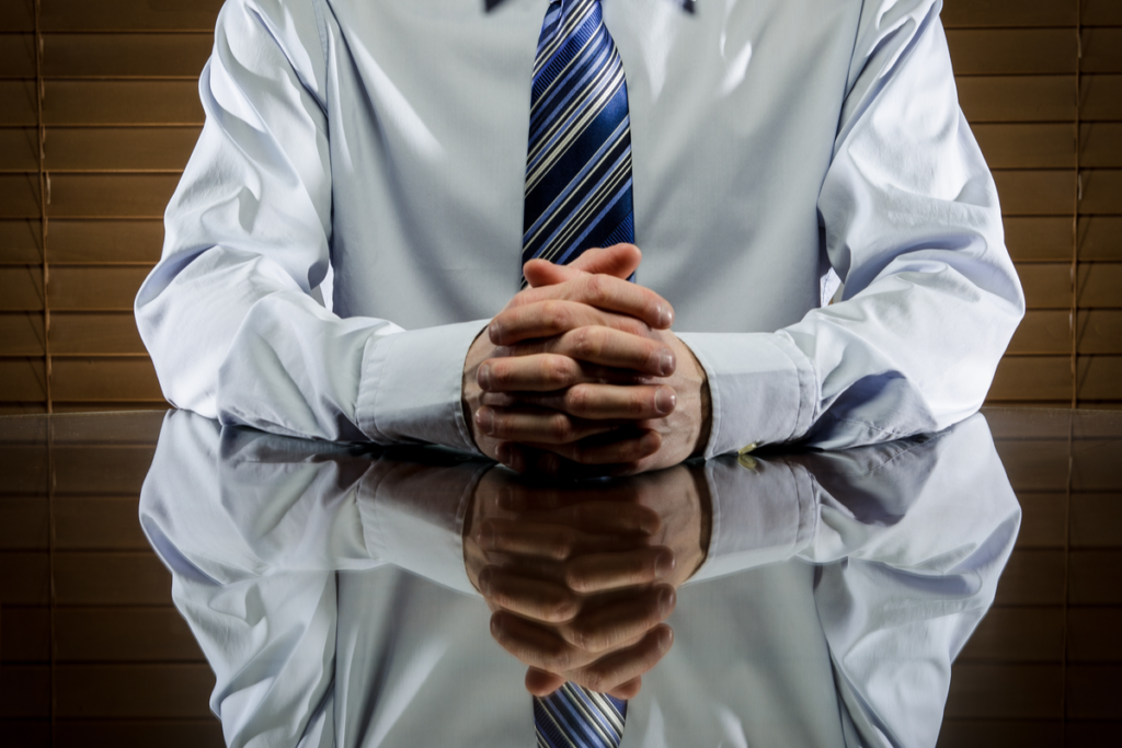 Man with folded hands, a type of non-verbal communication.