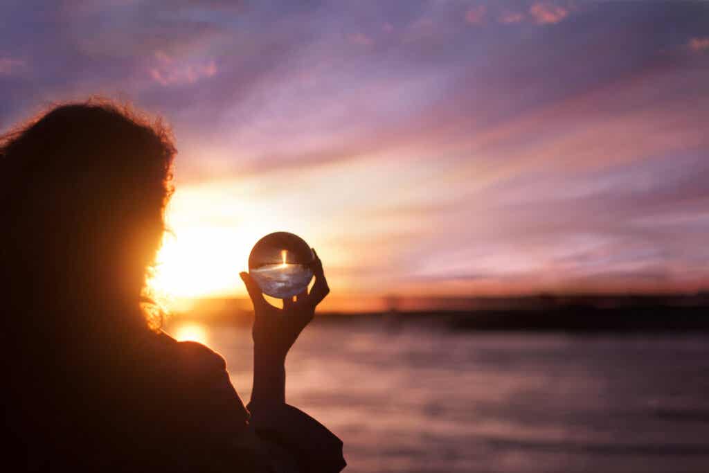 Mujer con bola de cristal haciéndose preguntas existenciales