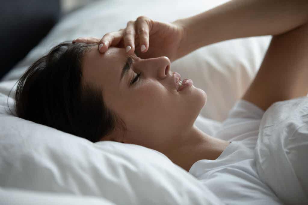 Tired woman waking up due to exploding head syndrome