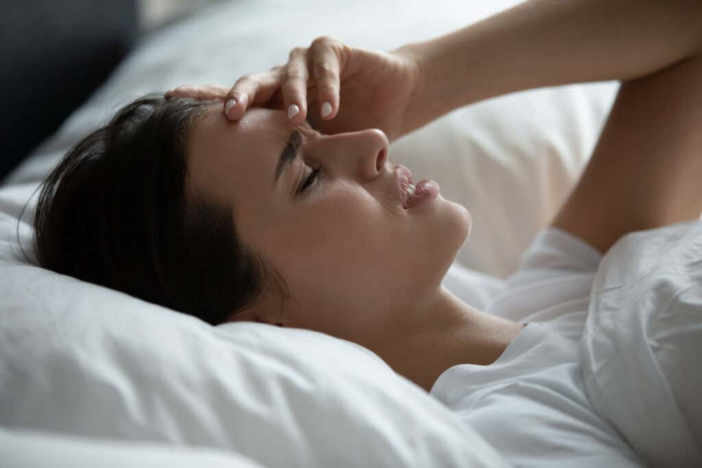 Femme fatiguée se réveillant à cause du syndrome de la tête qui explose