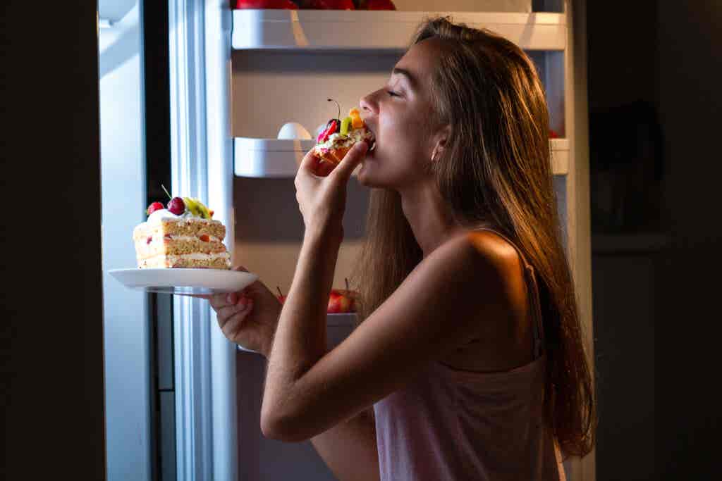 La donna che mangia di notte rappresenta che dormire male fa mangiare peggio.