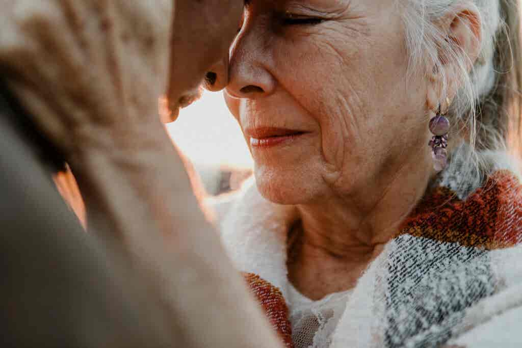 Eldre kvinne som klemmer partneren sin og utvikler sin seksuelle visdom