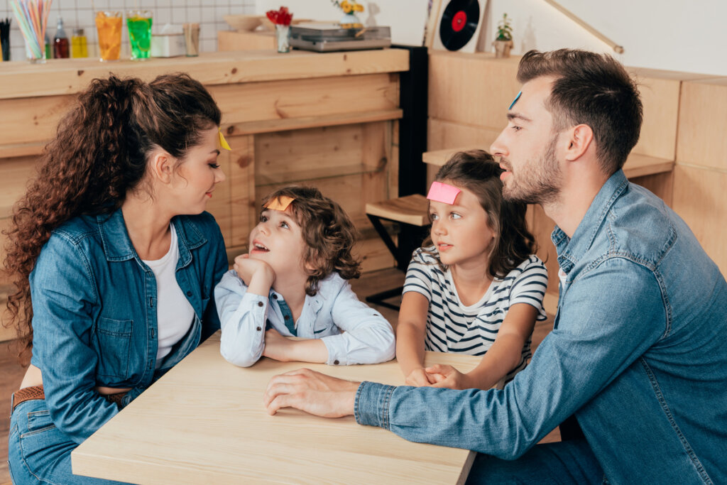 Parents jouant à des énigmes avec des enfants symbolisant les enfants d'orchidées et les enfants de pissenlit