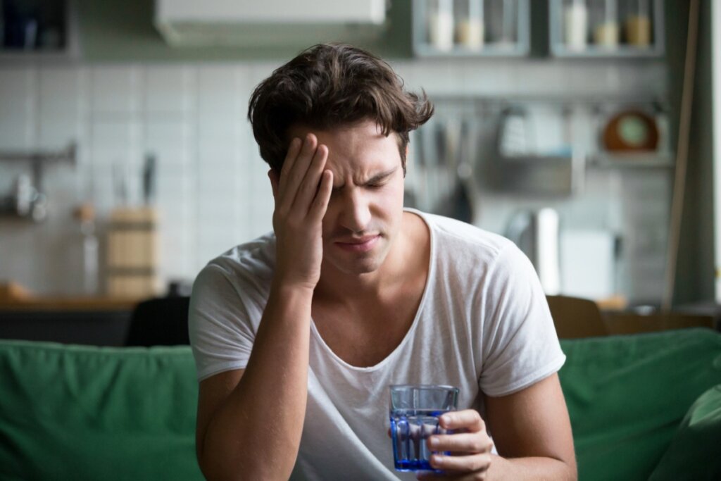 Un homme souffrant de douleur chronique tient un verre en pensant à l'indice de la douleur de McGill