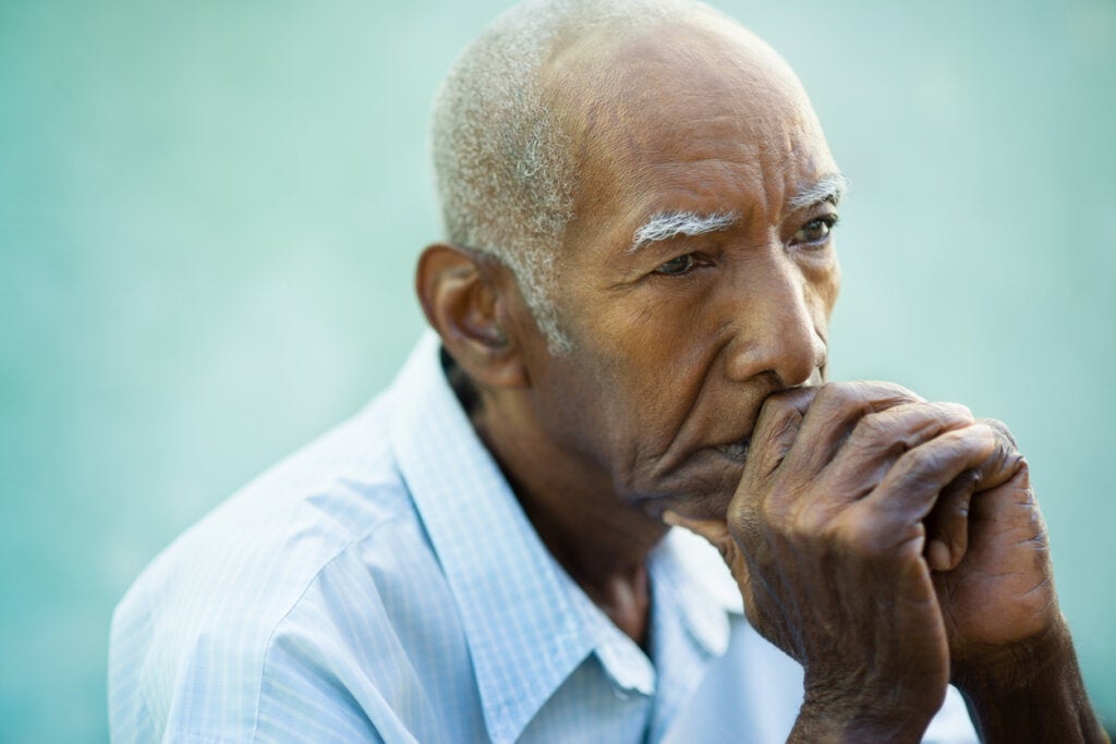 Homem idoso pensando que sofre de hipomimia