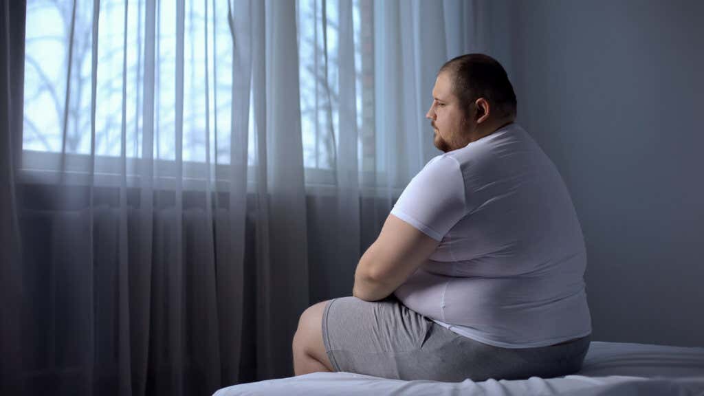 Homme triste pensant à l'obésité et aux troubles de l'alimentation