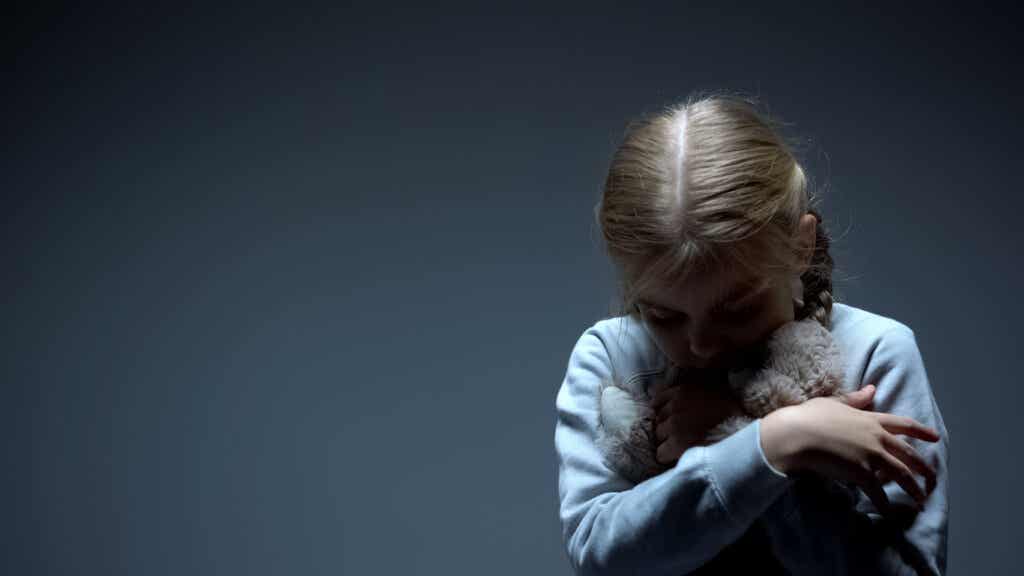 Sad girl hugging a stuffed animal