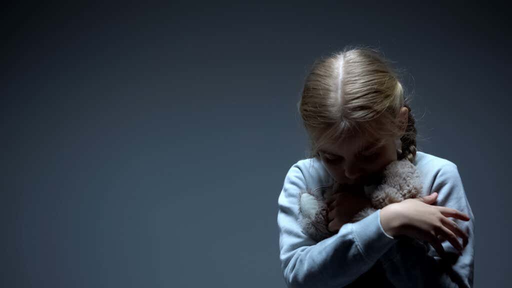 Smutna dziewczyna przytula wypchanego zwierzęcia