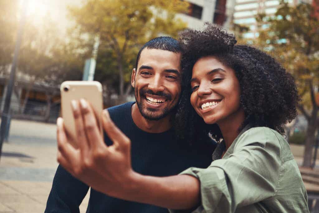 Par som tar en selfie, skildrer sosiale og paret.