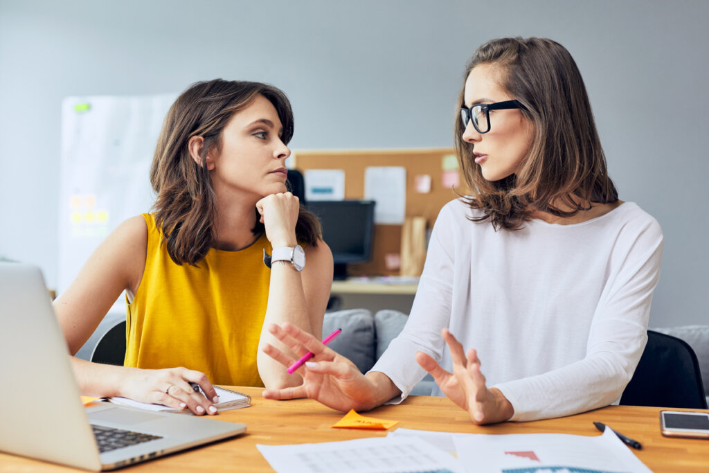 Two female coworkers talking about giving and receiving advice