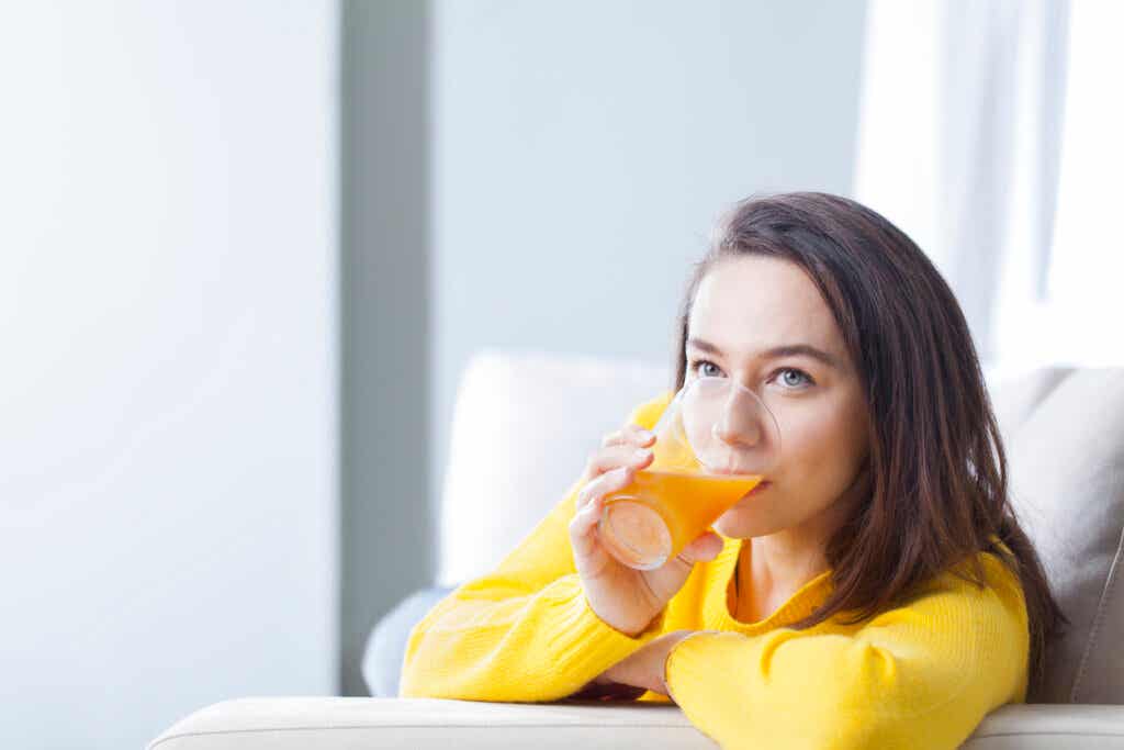 Kobieta pijąca sok pomarańczowy