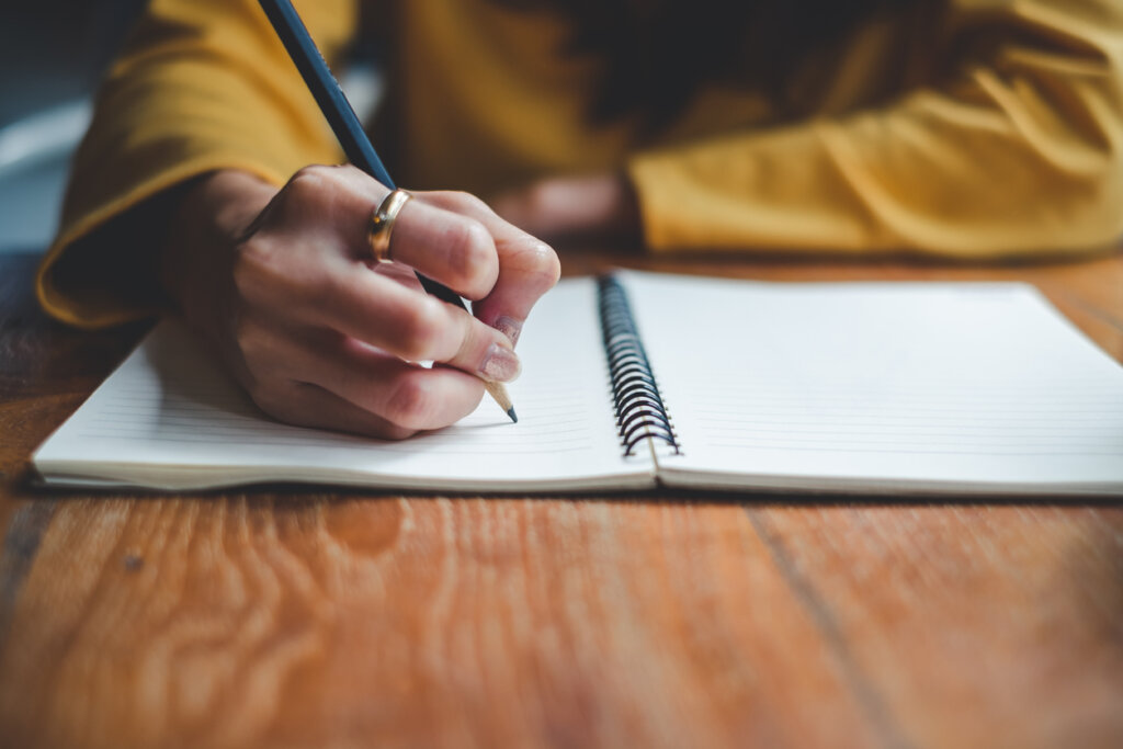 Femme écrivant sur les pensées négatives automatiques