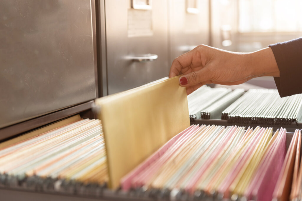 Mujer guardando carpeta en el archivador
