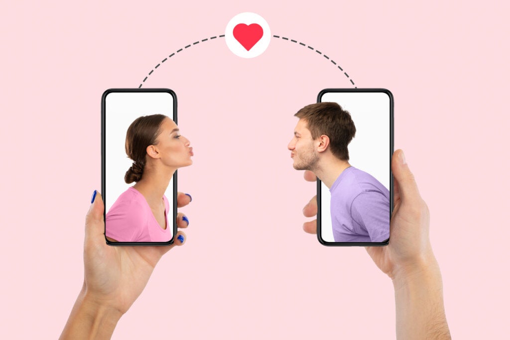 Mulher e homem no celular mandando um beijo