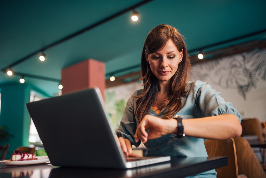 Femme regardant l'horloge au travail