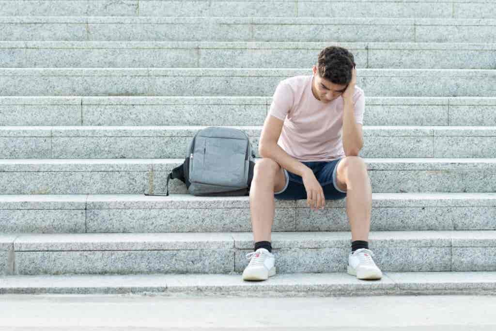 Adolescente triste sentado en las escaleras