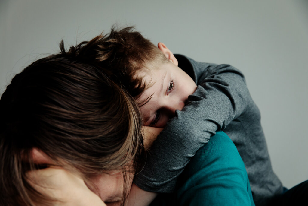 Madre llorando e hijo consolándola