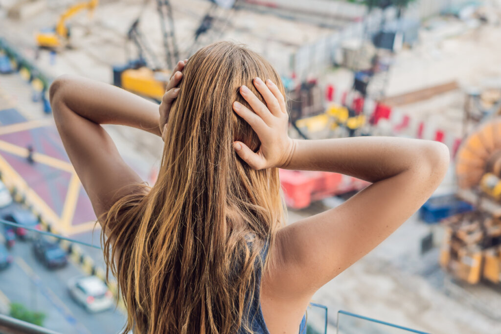 Mujer tapándose los oídos por la contaminación acústica