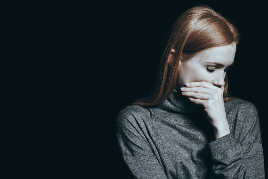 Trist jente med lukkede øyne og tenker på hvordan depresjon påvirker selvoppfatningen vår
