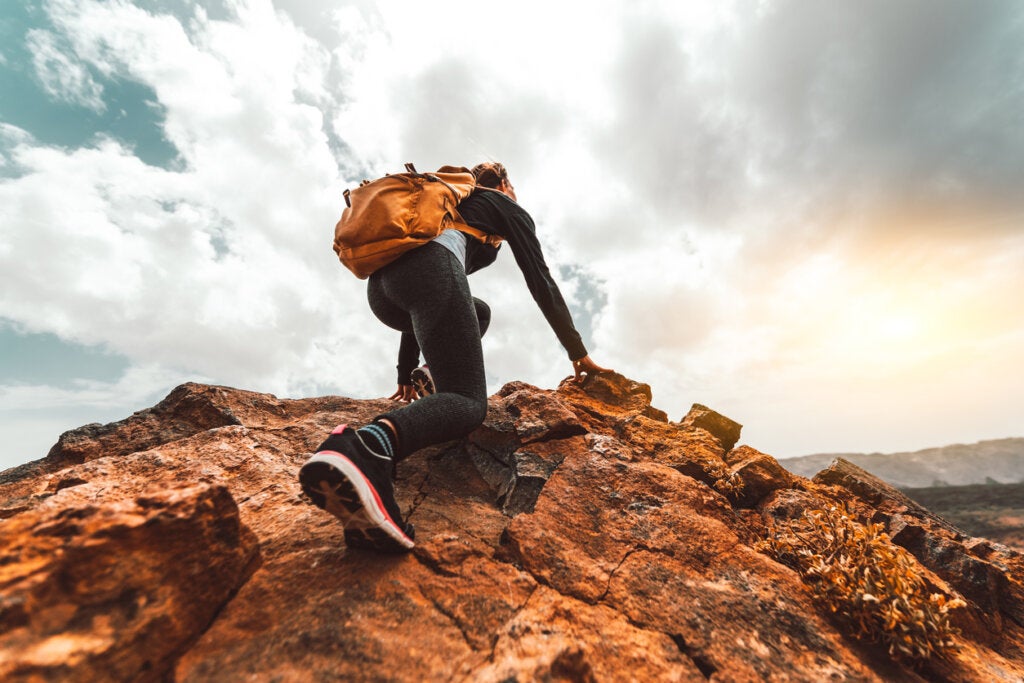 Escaladora subiendo una montaña representando el valor de confiar en ti mismo