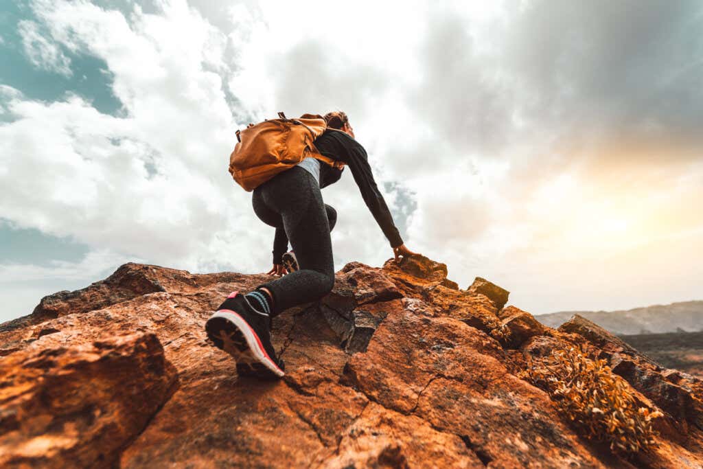 Alpinista escalando uma montanha representando o valor de confiar em si mesmo