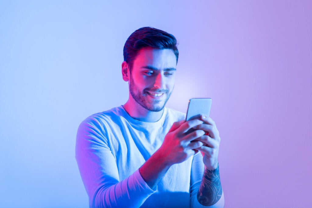Homme regardant le mobile symbolisant le thésauriseur numérique
