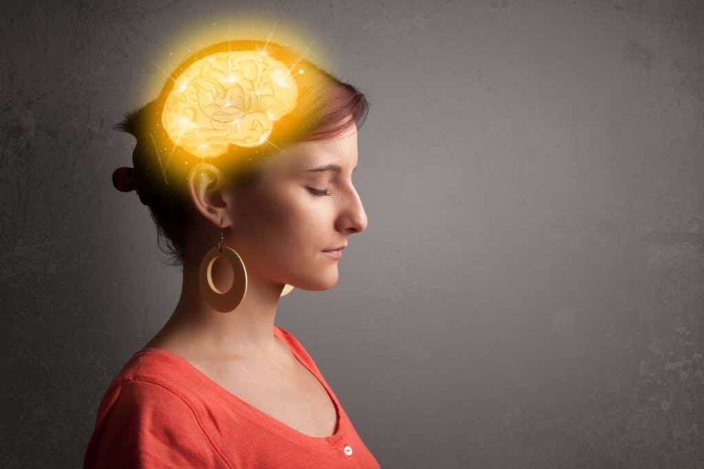 Mulher com cérebro iluminado simbolizando inteligência emocional e pensamento crítico