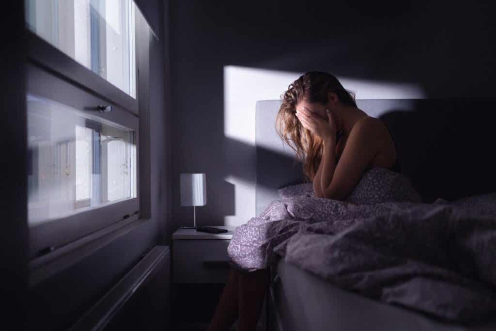 Trist kvinne er deprimert i sengen sin