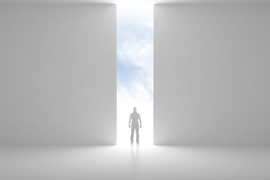 Hombre andando hacia una puerta con luz