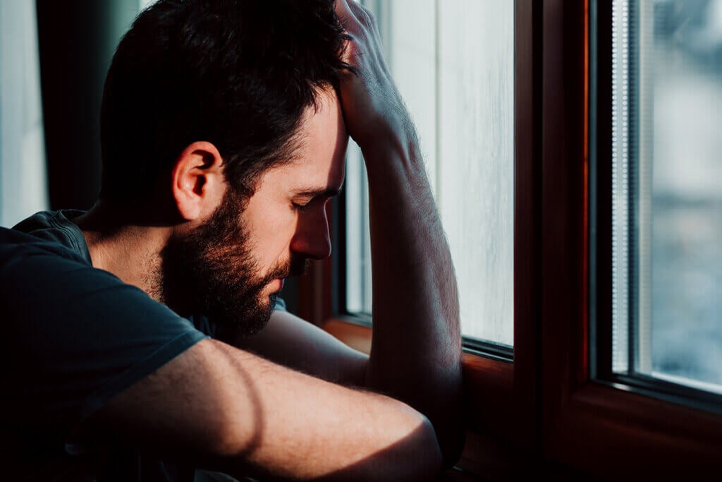 Anxious man looking out the window