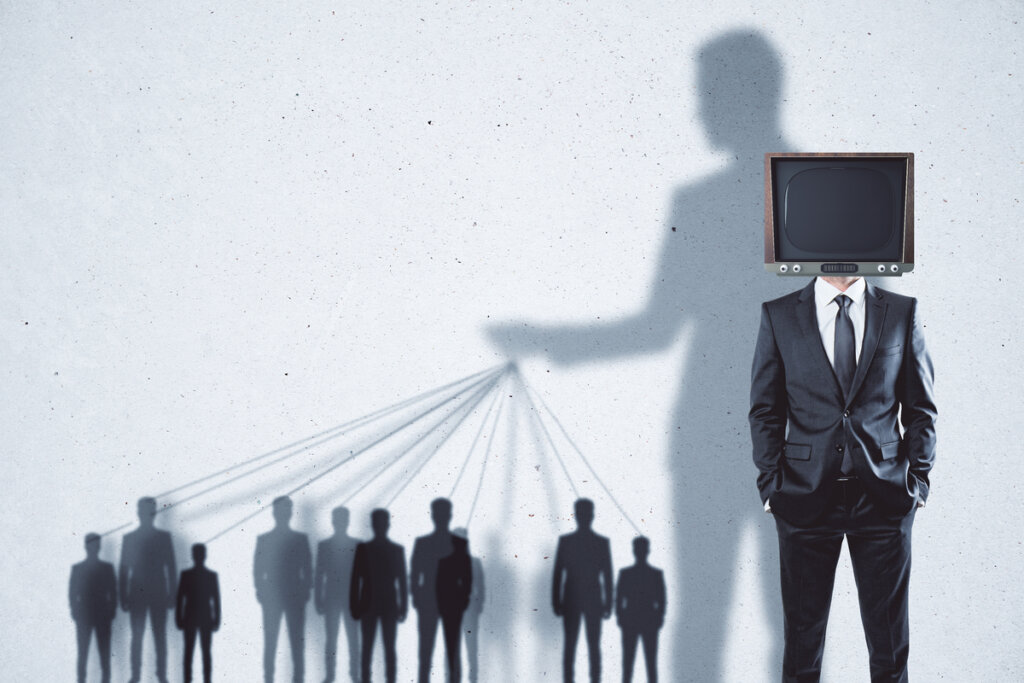 Hombre manipulando a personas por la tv