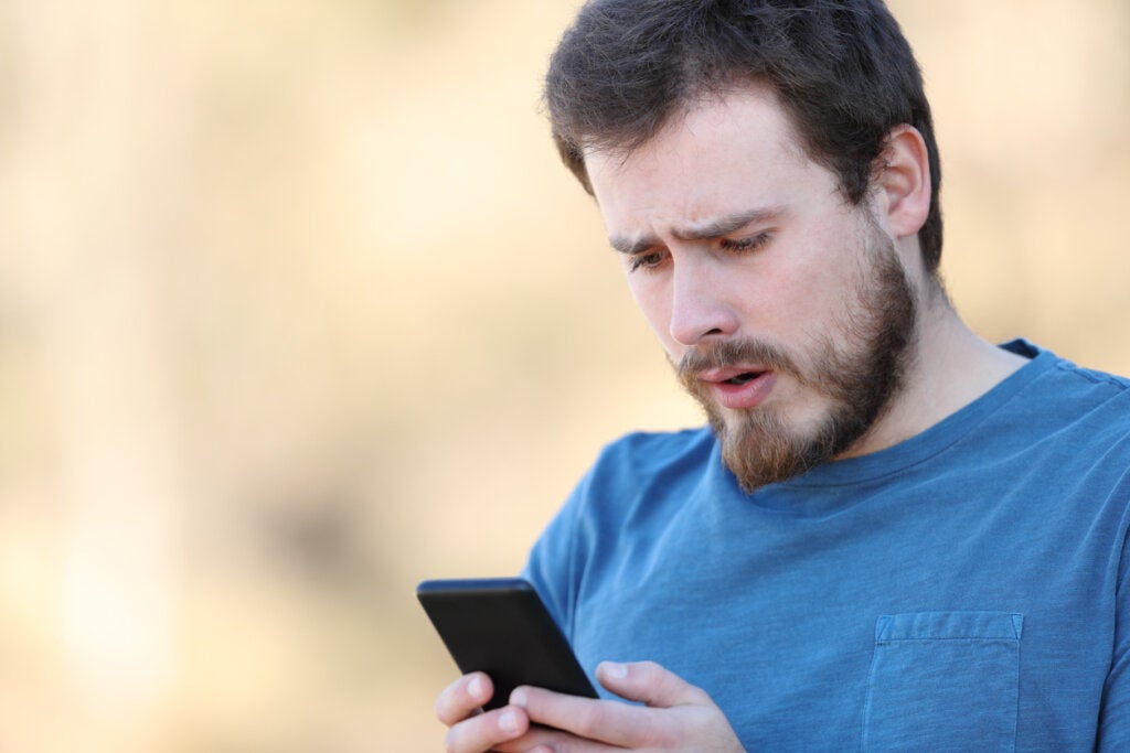 Worried man reading information on mobile