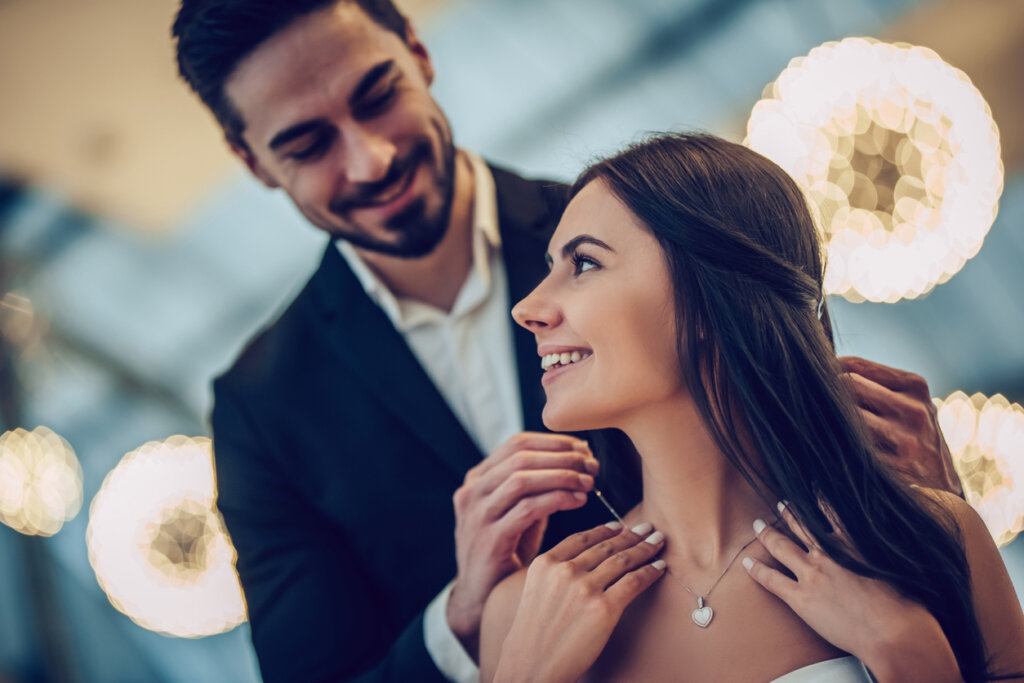 Un hombre le regala a su pareja un collar.