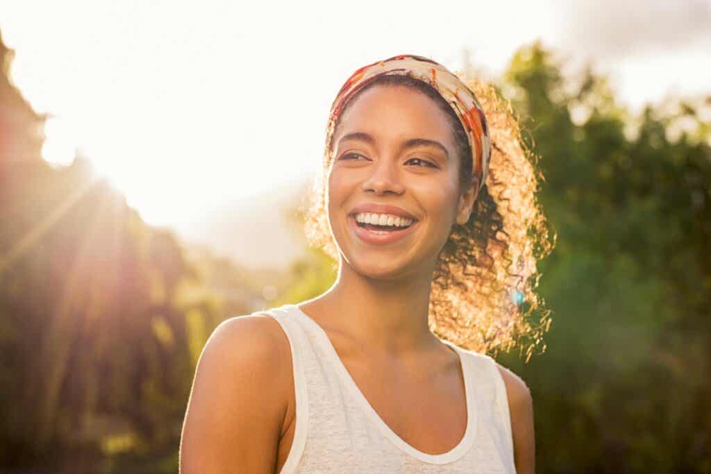 Afroamerikansk kvinne smiler ved solnedgang