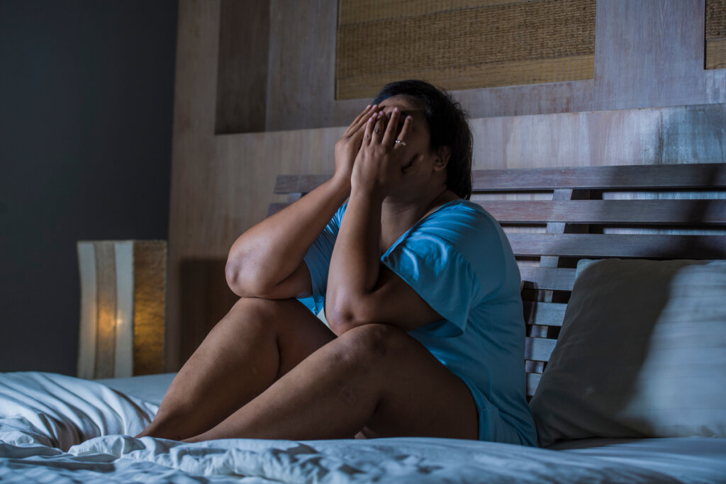 Mujer en la cama triste por herida de la humillación
