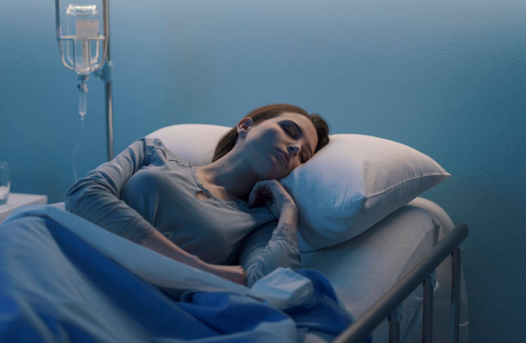 Sovende kvinne på sykehus, som representerer det som gir håp til de syke.