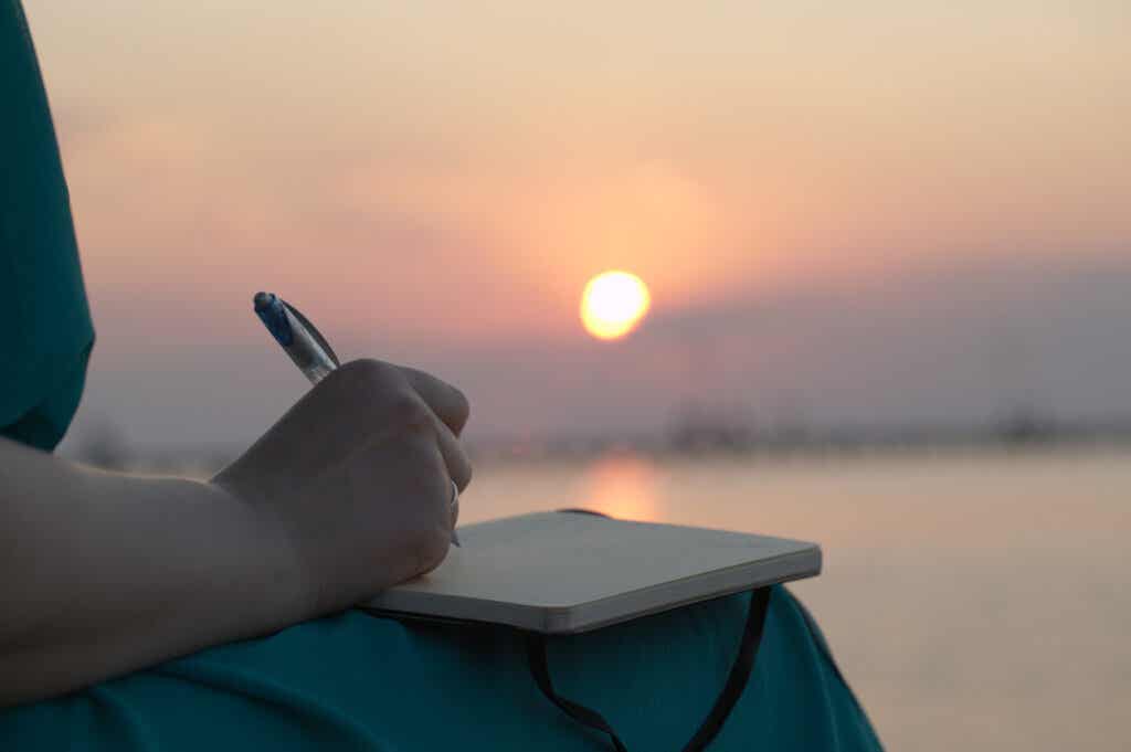 Kvinne skriver ved solnedgang på humørsporingsteknikker