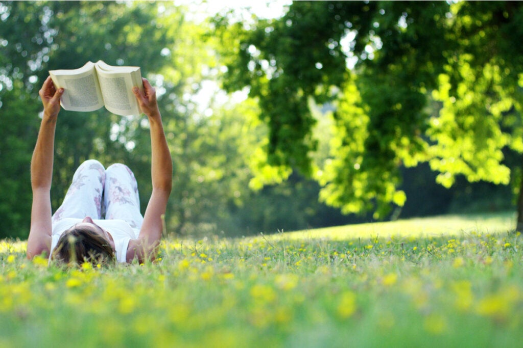 Mujer leyendo un libro al aire libre disfrutando de las historias con finales felices