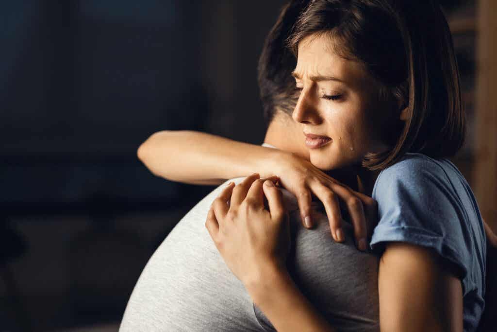 Płacząca kobieta przytulana przez partnera