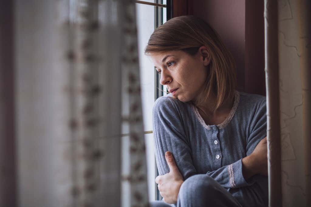 Woman sitting at the window thinking about whether to take time in the relationship