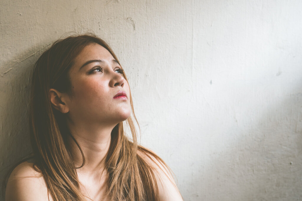 Donna triste che pensa alla violenza in famiglia.