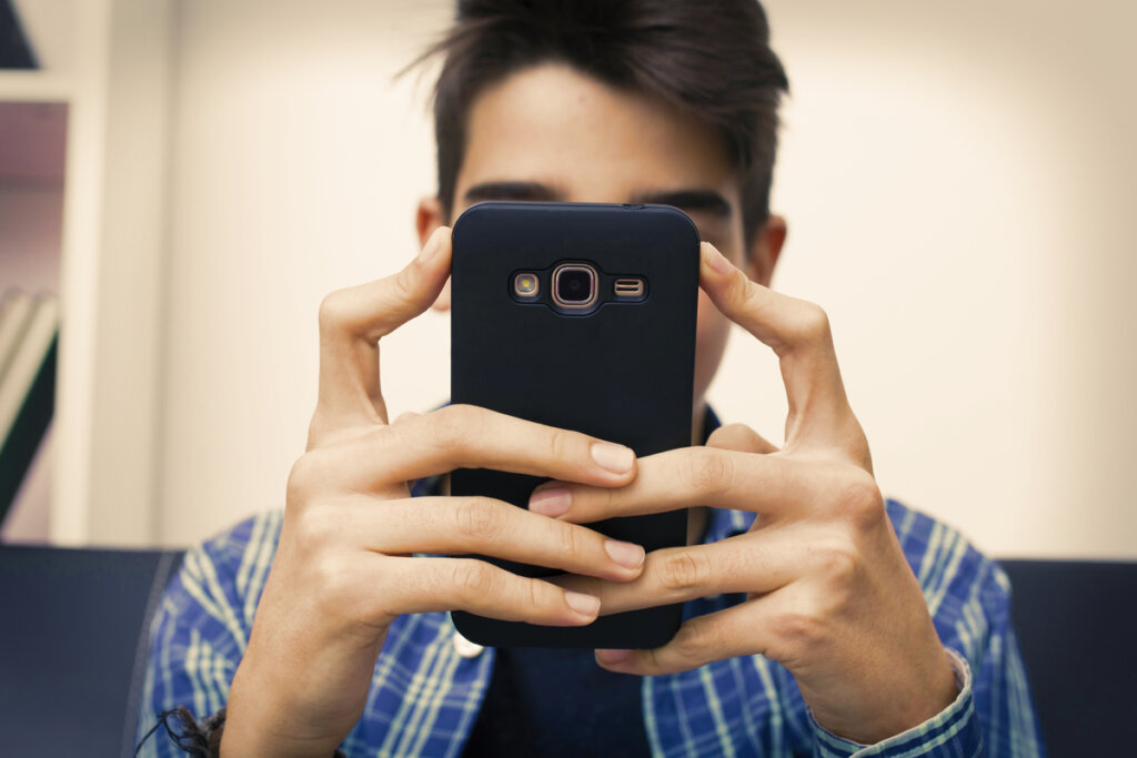 Adolescent avec le mobile pour symboliser qu'1 jeune sur 4 est raciste