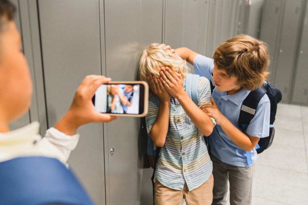 Children physically and emotionally harassing one of their classmates.