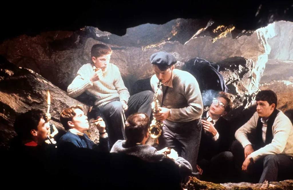 Studenter av professor John Keating, uttrykker ideene sine fritt i en hule.