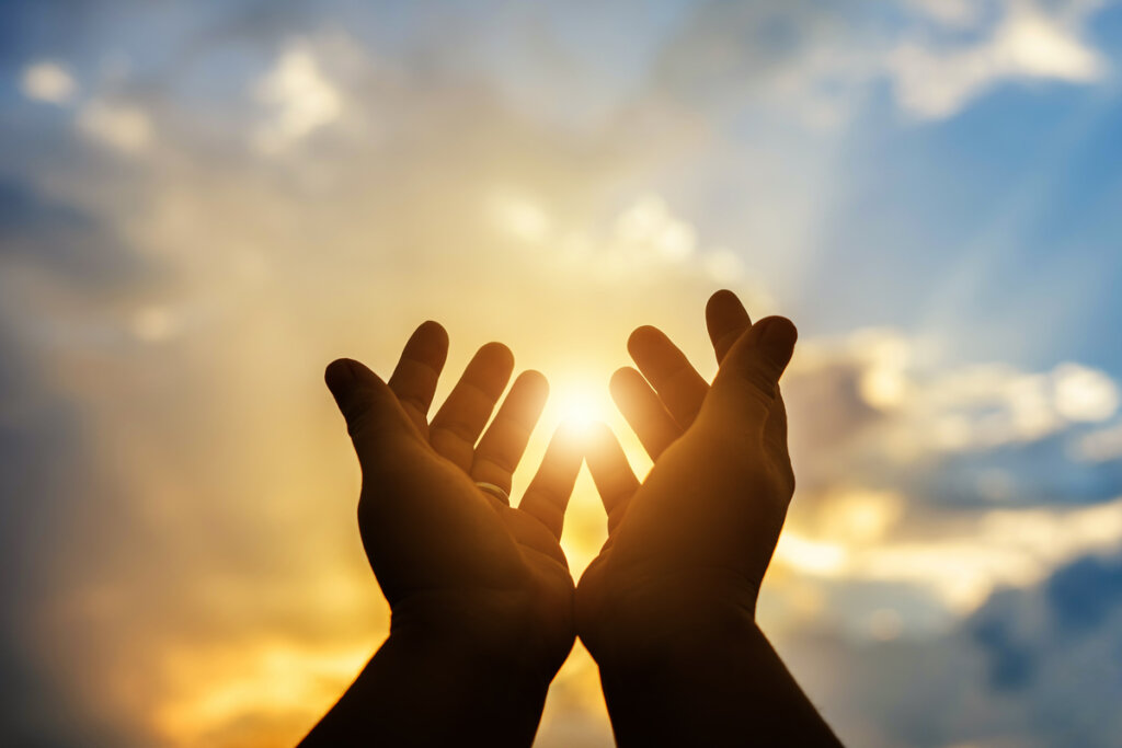 Hands pointing to the sky symbolizing the most important positive emotions