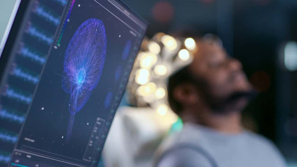 Monitory wyświetlają graficzny model mózgu i odczyt EEG symbolizujący neurotechnologie
