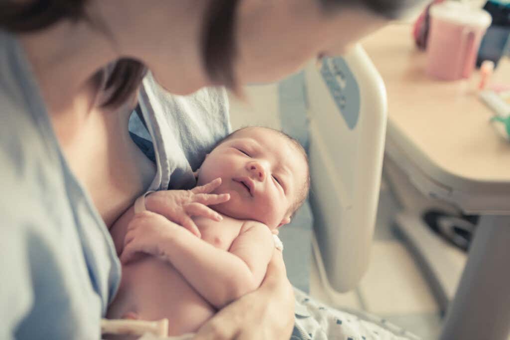 Mulher com seu filho nos braços após o parto