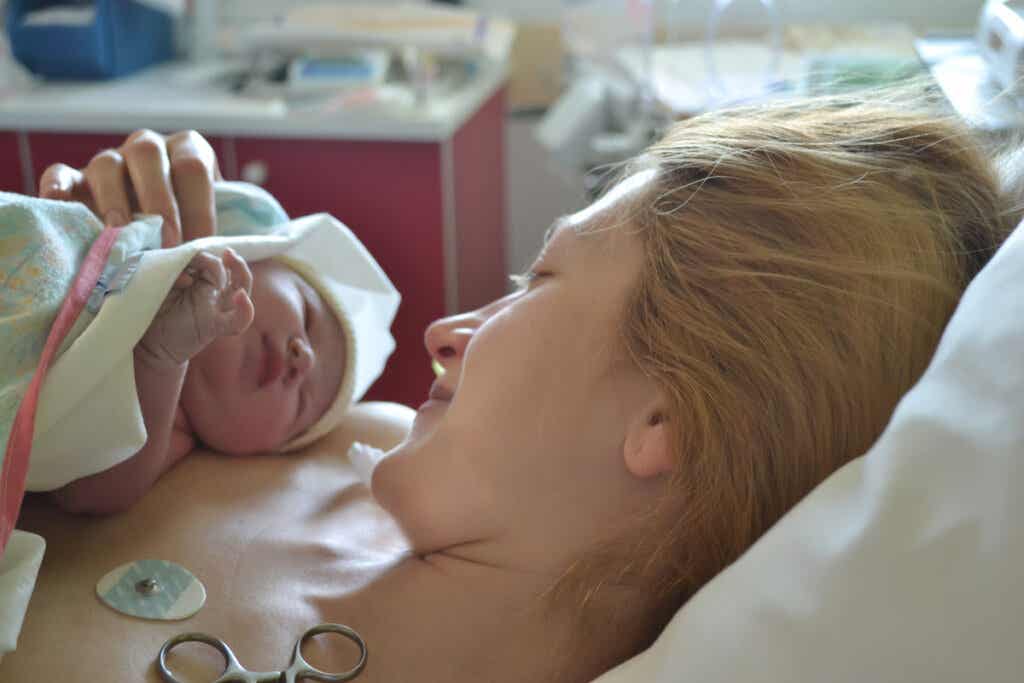 Kobieta patrząca na swoje dziecko po porodzie. Szanowanie woli matki.