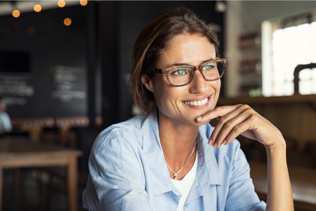 Mujer sonriendo mientras piensa en el lado positivo del orgullo