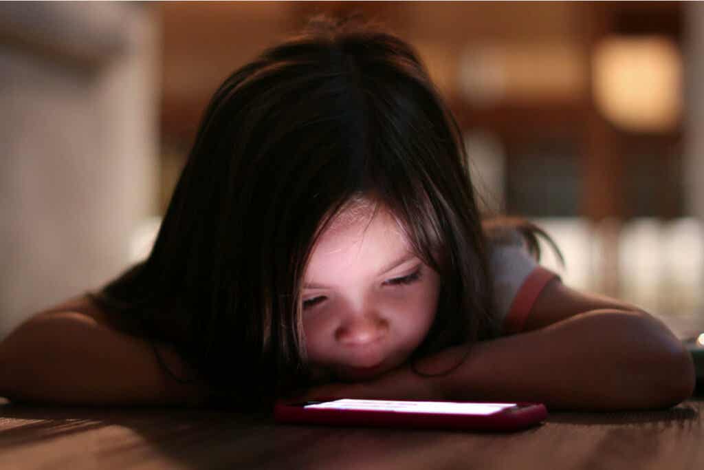 Petite fille avec le mobile symbolisant ce que c'est que d'utiliser le mobile la nuit